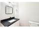 Stylish powder room with black countertop, modern mirror, and sleek fixtures at 5352 Brookside Dr, Broomfield, CO 80020