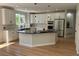 Bright kitchen with white cabinetry, marble counters, black island and stainless steel appliances at 5352 Brookside Dr, Broomfield, CO 80020