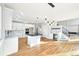 Open kitchen with dining area includes a wine fridge, stair case and black countertop island at 5352 Brookside Dr, Broomfield, CO 80020