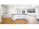 Open kitchen has a large black countertop island and bright hardwood floors at 5352 Brookside Dr, Broomfield, CO 80020
