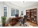 Bright office featuring a built-in bookshelf, a large desk and natural light from windows at 5352 Brookside Dr, Broomfield, CO 80020