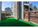 Exterior shot of a fenced backyard with artificial turf and a stone chimney on the house at 11605 E Cornell Cir, Aurora, CO 80014