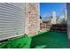 Side yard view with artificial turf and stone chimney extending up the side of the home at 11605 E Cornell Cir, Aurora, CO 80014
