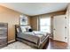 Cozy bedroom with rustic wood frame bed, window, dark hardwood floors, and decorative artwork at 11605 E Cornell Cir, Aurora, CO 80014