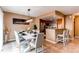 Modern dining room with a white table, stylish chairs, contemporary lighting, and an adjacent breakfast bar at 11605 E Cornell Cir, Aurora, CO 80014