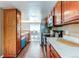 Galley kitchen featuring wood cabinets, stainless steel appliances, stone countertops, and open view to the dining area at 11605 E Cornell Cir, Aurora, CO 80014