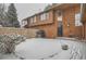 Snowy backyard with stone wall and small trees at 12136 E 2Nd Dr, Aurora, CO 80011