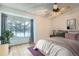 Bright bedroom with large window, ceiling fan, and wood-look flooring at 12136 E 2Nd Dr, Aurora, CO 80011