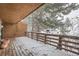 Covered deck with wooden railing and snow view at 12136 E 2Nd Dr, Aurora, CO 80011