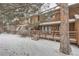 Townhouse exterior with snowy yard and wooden deck at 12136 E 2Nd Dr, Aurora, CO 80011