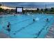 Large community pool with movie screen and many swimmers enjoying a summer day at 6112 Black Mesa Rd, Frederick, CO 80516