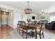 Open concept dining room with wooden table, chandelier, and living room view at 6112 Black Mesa Rd, Frederick, CO 80516