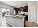 Modern kitchen with dark cabinets, stainless steel appliances, and an island at 6112 Black Mesa Rd, Frederick, CO 80516