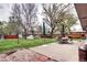 Spacious backyard with patio furniture, mature trees, and lush green lawn at 6365 S Valleyview St, Littleton, CO 80120
