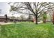 Expansive backyard featuring lush grass, a patio set, mature trees, and a small shed at 6365 S Valleyview St, Littleton, CO 80120