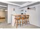Finished basement wet bar with tile countertop, three chairs, and shelving; perfect for entertaining guests at 6365 S Valleyview St, Littleton, CO 80120