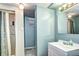 Vintage bathroom with white tile shower, light blue walls, and updated vanity at 6365 S Valleyview St, Littleton, CO 80120