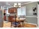 Dining area featuring a modern chandelier, wooden table, stainless steel appliances, and sleek wooden cabinets at 6365 S Valleyview St, Littleton, CO 80120