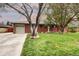 Inviting brick home showcasing a well-maintained lawn, mature trees, and an attached garage with space for two cars at 6365 S Valleyview St, Littleton, CO 80120