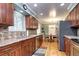 Updated kitchen with stainless steel appliances, wooden cabinets, hardwood floors and an adjacent breakfast nook at 6365 S Valleyview St, Littleton, CO 80120