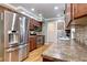 Well-equipped kitchen with stainless steel appliances, custom wooden cabinets, and stone countertops, offering modern convenience at 6365 S Valleyview St, Littleton, CO 80120
