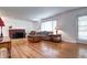 Spacious living room with hardwood floors, a cozy brick fireplace, and ample natural light from the large windows at 6365 S Valleyview St, Littleton, CO 80120