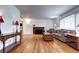 Bright living room featuring hardwood floors, brick fireplace, neutral walls, and an open layout, perfect for entertaining at 6365 S Valleyview St, Littleton, CO 80120