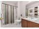 Bathroom featuring a shower-tub combo, classic fixtures, a decorative mirror, and tiled floors at 4451 S Ammons St # 5-307, Littleton, CO 80123