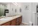 This bathroom features a double sink vanity with wooden cabinets, and a large mirror at 4451 S Ammons St # 5-307, Littleton, CO 80123