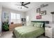 The bedroom has a ceiling fan, a double bed with green patterned bedding, and a window at 4451 S Ammons St # 5-307, Littleton, CO 80123