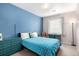 The bedroom has a blue accent wall, with coordinating furniture and a window with coverings at 4451 S Ammons St # 5-307, Littleton, CO 80123