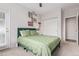 A nicely staged bedroom features a green bed, closet and a door out to a balcony at 4451 S Ammons St # 5-307, Littleton, CO 80123