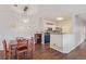 Dining room features a modern chandelier, wood floors, a wine rack, and an adjacent kitchen area at 4451 S Ammons St # 5-307, Littleton, CO 80123