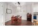 Elegant dining room with hardwood floors, a dark wood table set for four, a crystal chandelier and a wine cabinet at 4451 S Ammons St # 5-307, Littleton, CO 80123