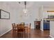 Dining area with table and chairs next to the kitchen features hardwood floors and a modern chandelier at 4451 S Ammons St # 5-307, Littleton, CO 80123