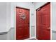 Red apartment door, number 307, adorned with a floral wreath and flanked by a second red door in a neutral hallway at 4451 S Ammons St # 5-307, Littleton, CO 80123