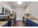 Updated kitchen with stainless steel appliances, stylish blue and white cabinets, and ample counter space at 4451 S Ammons St # 5-307, Littleton, CO 80123