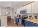 View of the kitchen showcasing the stainless microwave and stove and a view to the dining space beyond at 4451 S Ammons St # 5-307, Littleton, CO 80123