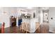 Modern kitchen with white cabinets, stainless steel appliances, a breakfast bar, and hardwood floors overlooking the dining area at 4451 S Ammons St # 5-307, Littleton, CO 80123