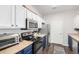 Well-lit kitchen featuring stainless steel appliances, white and blue cabinets, and hardwood floors with dining area adjacent at 4451 S Ammons St # 5-307, Littleton, CO 80123
