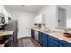 The kitchen features blue lower cabinets, stainless steel appliances, and wood-look floors at 4451 S Ammons St # 5-307, Littleton, CO 80123