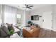 Open-concept living room features a gray sectional, leather chair, and a sliding door to a balcony for natural light at 4451 S Ammons St # 5-307, Littleton, CO 80123