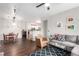 Bright living room with a gray sectional sofa, a leather armchair and hardwood floors leading to an open dining area at 4451 S Ammons St # 5-307, Littleton, CO 80123