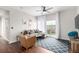 Bright living room with hardwood floors, a gray sectional, leather armchair and a sliding door that opens to a balcony at 4451 S Ammons St # 5-307, Littleton, CO 80123