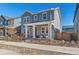 A beautiful gray two-story home features a cozy front porch and well-maintained landscaping at 9080 W 100Th Way, Broomfield, CO 80021