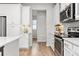 Contemporary kitchen featuring stainless steel appliances, white cabinets and light wood flooring at 9080 W 100Th Way, Broomfield, CO 80021