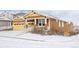 Inviting two-story home with a cozy front porch and two-car garage, enveloped in a blanket of fresh snow at 19473 W 58Th Pl, Golden, CO 80403