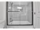 Bathroom featuring a bathtub-shower with glass doors and tiled walls at 11788 E Atlantic Pl, Aurora, CO 80014