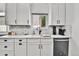 Kitchen features white cabinets, marble backsplash, stainless steel dishwasher, and view from the window at 11788 E Atlantic Pl, Aurora, CO 80014