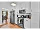 Bright kitchen with stainless steel appliances, white cabinets, and hardwood floors at 11788 E Atlantic Pl, Aurora, CO 80014